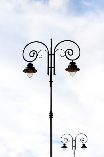 Vintage style garden lamp in the city park during sunny day