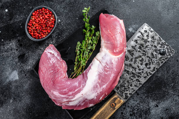 сырое мясо свиной вырезки на мраморной доске. черный фон. вид сверху - veal raw meat pink стоковые фото и изображения