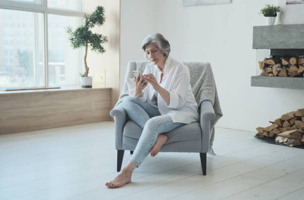 istock Relaxed mature old woman using mobile phone applications 1344153232