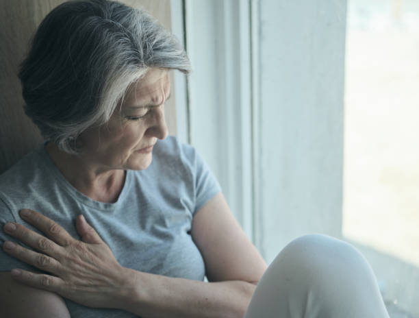 anciana anciana enferma discapacitada, mujer triste con dolor y sufrimiento sentada junto a la ventana del hospital. - pessimist women one person caucasian fotografías e imágenes de stock