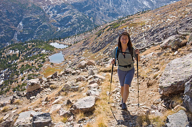 Woman Hiking Above Alpine Lakes.  Asian woman enjoying the outddors recreating in the mountains.  Scenic location with rugged rocky terrain and mountain backdrop.  Converted from 12-bit Raw file.  sRGB color space.  Other related images:
