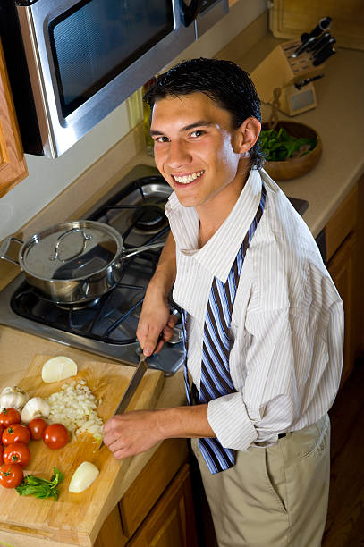 istock Young Urban Professional Man Chops Onion 134416377