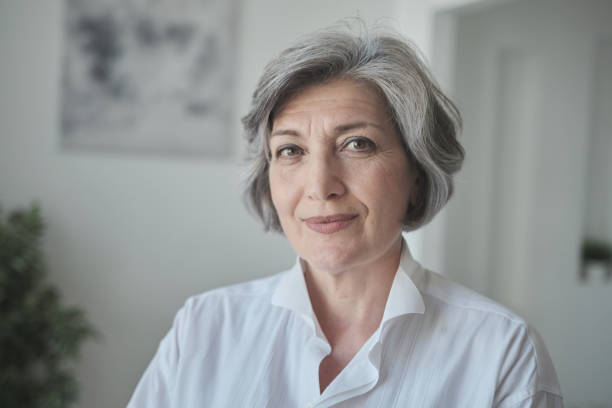 istock A confident, educated older lady executive manager stands in a bright contemporary workplace and appearing serious 1344168734
