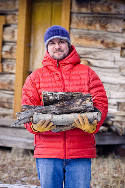 istock Man Holding Firewood and Smiling at Cabin 134416888