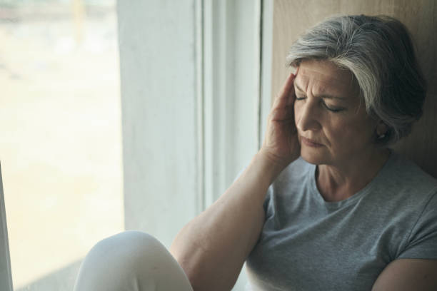 anciana anciana masajeando sus sienes para reducir su dolor de cabeza. - pessimist women one person caucasian fotografías e imágenes de stock