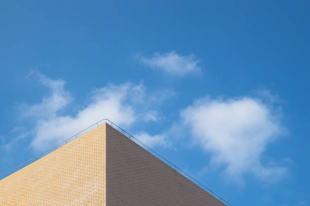 part of the light yellow building under the blue sky and white clouds - roof tile architectural detail architecture and buildings built structure imagens e fotografias de stock