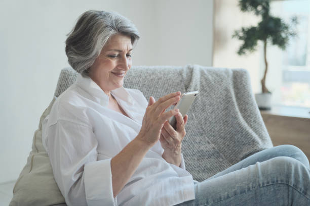 istock Happy older middle aged female using smartphone, enjoying chat with children 1344174211