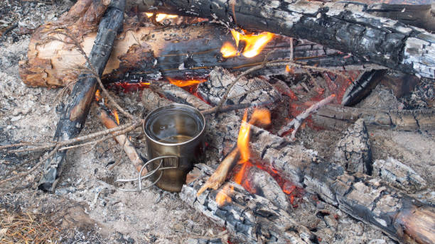 a metal mug with water is in the fire stock photo