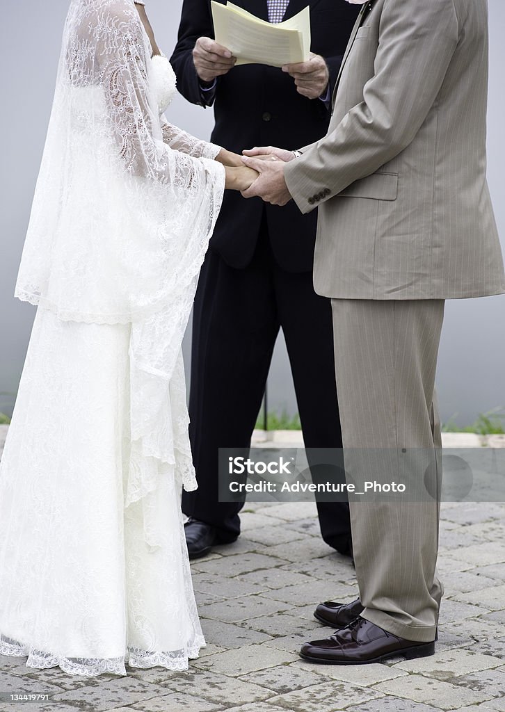 Sposa e lo sposo di cambio nozze tenendo la mano al matrimonio - Foto stock royalty-free di Adulto