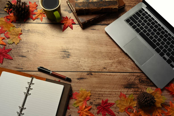 istock Laptop computer, coffee cup, notebook and autumn maple leaves on wooden table. 1344198153