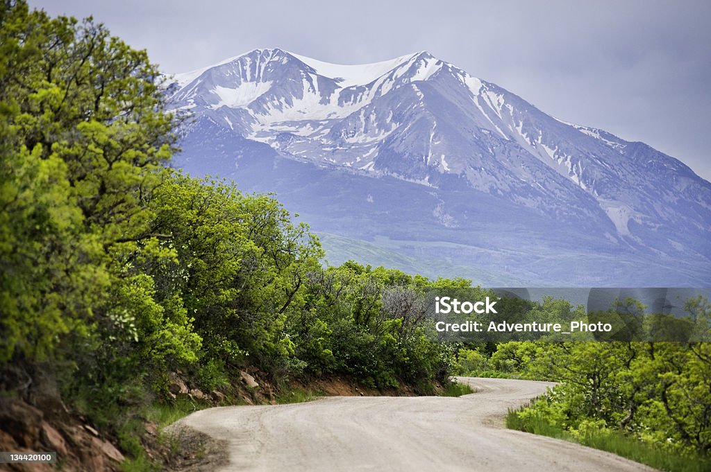Strada in terra battuta e una splendida vista sulle montagne - Foto stock royalty-free di Colorado