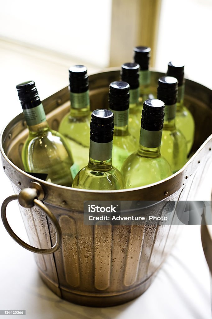 Botellas de vino blanco en bronce del cubo de hielo - Foto de stock de Botella libre de derechos