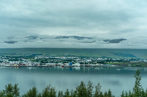 Panorama view of Akureyri  across Eyjafjordur fjord in North Iceland. Mountains in background are covered with clouds.