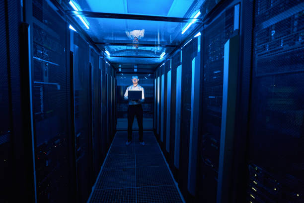 istock Server administrator standing in hallway of data center 1344207047