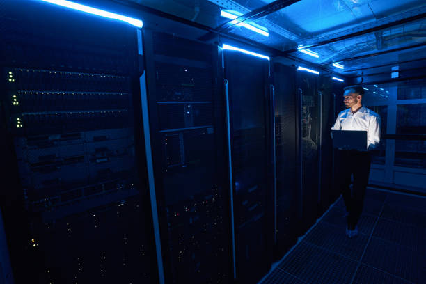 istock Male server technician walking with laptop in data center room 1344207049