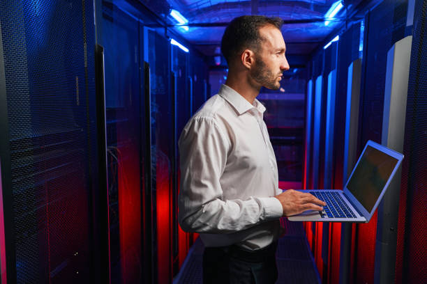 istock Bearded concentrated professional it specialist working with telecommunication equipments in database server place 1344208044