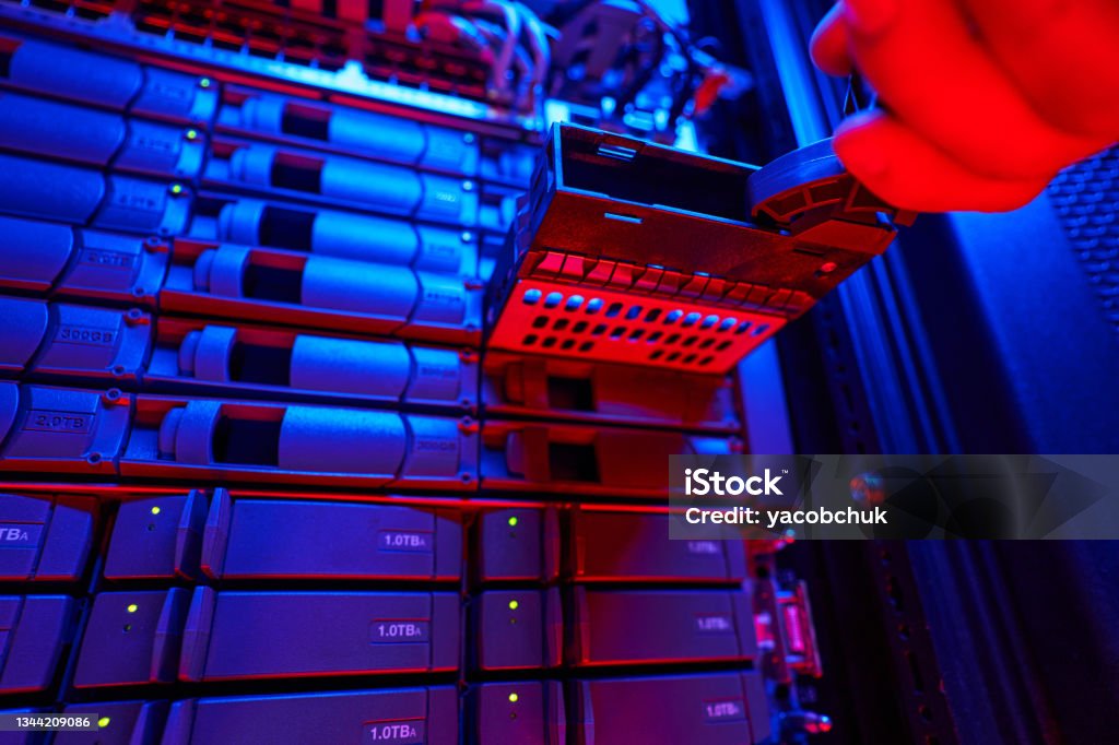 It engineer is disassembling and repairing computer server in data center Close up of unrecognized male hand holding HDD disk in server room Spatholobus Suberectus Dunn Stock Photo