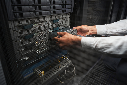 Close up side view portrait of beautiful man hands with it equipment and working in server room