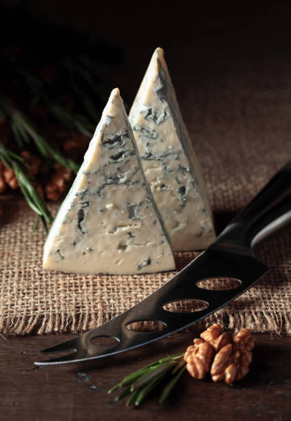 Blue cheese with walnuts and rosemary. Blue cheese with walnuts and rosemary on an old wooden table. roquefort cheese stock pictures, royalty-free photos & images