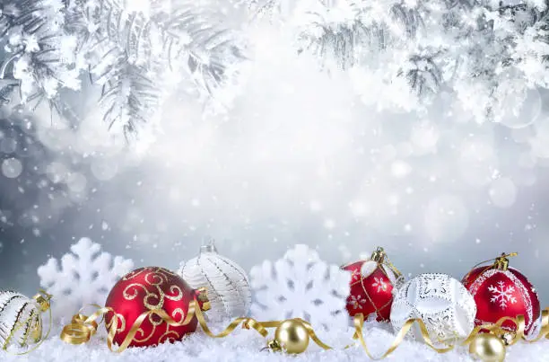 Photo of Template festive background  with red and white Christmas balls, snowflakes in snow.