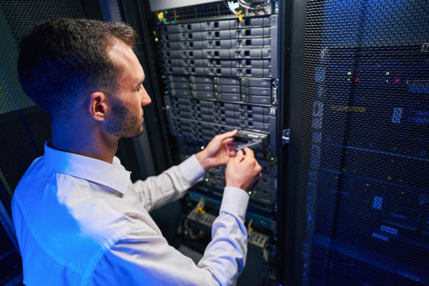 istock Busy maintenance administrator disassembling and repairing computer server in room indoors 1344210201