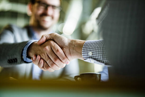 Close up of businessmen came to an agreement in the office. Close up of unrecognizable businessmen shaking hands on a meeting in the office. Copy space. merger stock pictures, royalty-free photos & images