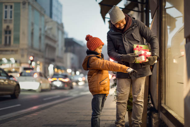 Father and son, Christmas window shopping Father and son Christmas window shopping during the COVID19 pandemic window shopping at night stock pictures, royalty-free photos & images