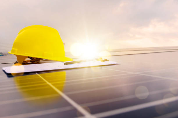 istock Solar cell contractor document with orange engineering team helmet on solar cells panels 1344219141