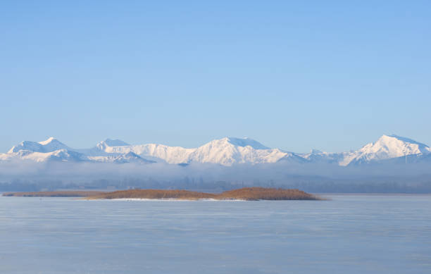 istock snowbound mountain chain beyond frozen lake at bright winter day 1344226066