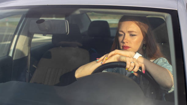 istock a red-haired beautiful girl drives a car 1344227034