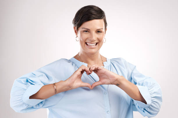 istock Cropped portrait of an attractive young woman making a heart shape with her hands in studio against a grey background 1344228708