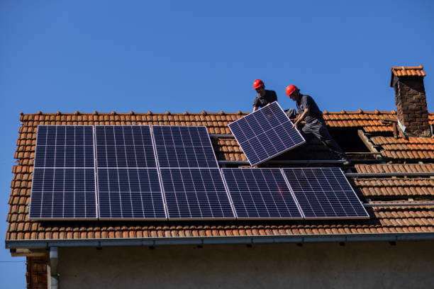 istock Two solar panel installers mounting solar panels on roof of house 1344229691