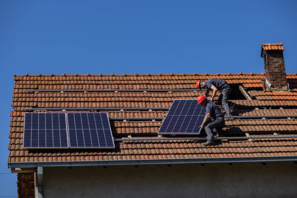 istock Blue collar workers installing solar panels on roof of house 1344229844