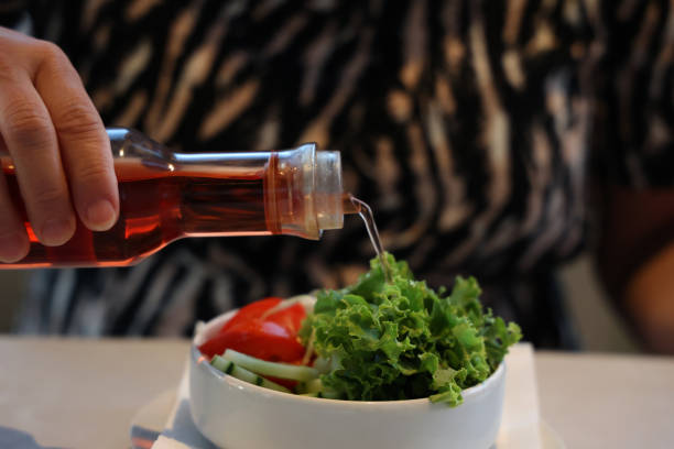Chef decorating a plate with tomatos, basil, garlic, olive oil and balsamic vinegar