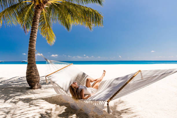 istock Young happy woman having fun in hammock on the beach. 1344231362