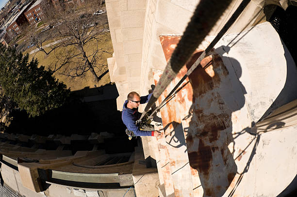 istock Man Working Prepping for Painting From High Angle Rope 134423307