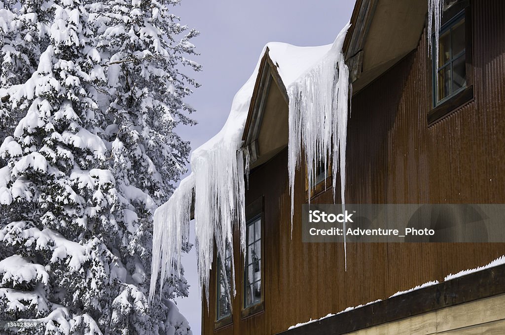 Ghiaccio appesi tetto di una casa in inverno - Foto stock royalty-free di Esterno di un edificio