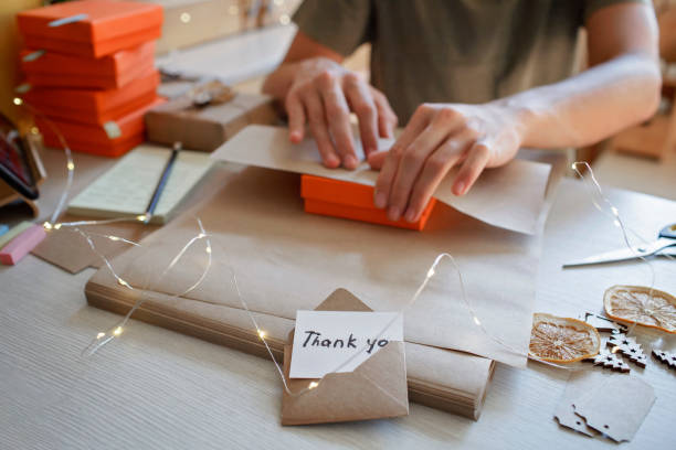 istock Young worker packing Christmas gift boxes for clients, family small business, distant work from home 1344235249