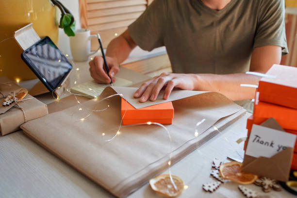 istock Young worker packing Christmas gift boxes for clients, family small business, distant work from home 1344235269