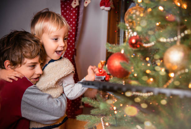 istock Children Play with Toy Train on Christmas Tree 1344236289