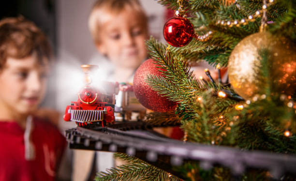 istock Children Play with Toy Train on Christmas Tree 1344236391