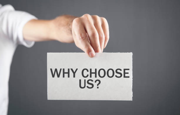 istock Man showing Why Choose Us message on paper. 1344236590