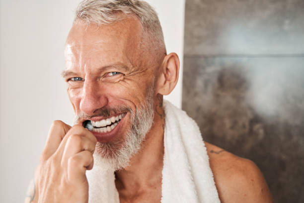 istock Mature man brushing his teeth with toothbrush 1344236600