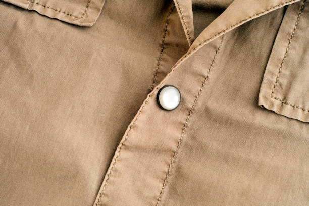 Close-up of button on a beige shirt.