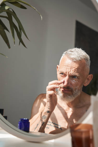 istock Mature man applying cosmetic cream on his face 1344236668