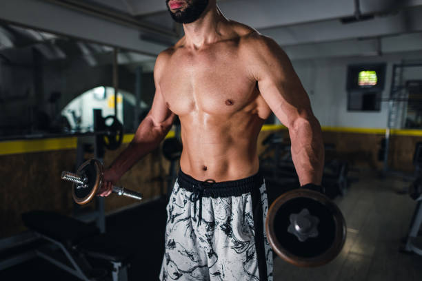 istock Strong muscular man exercises with weights 1344237617