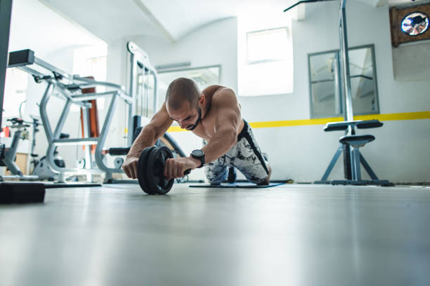 istock Man exercises abs with abdominal toning wheel 1344237647