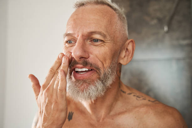 istock Mature man applying anti-aging cream on his face 1344240166