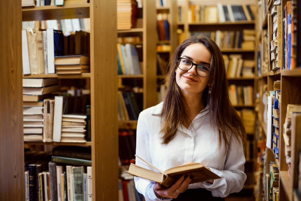 istock Woman reading a book in the library 1344242141