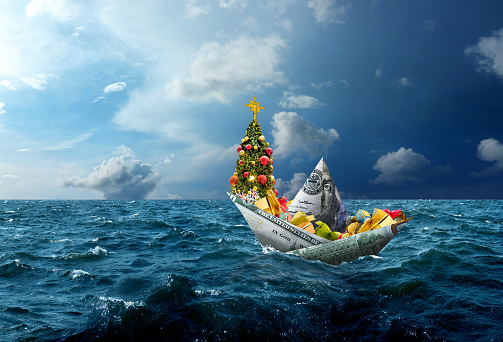 Conceptual money boat and Christmas gifts on stormy seascape